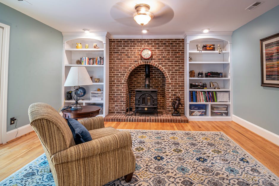 A cozy, well-organized living room with a bookshelf sorted by color.